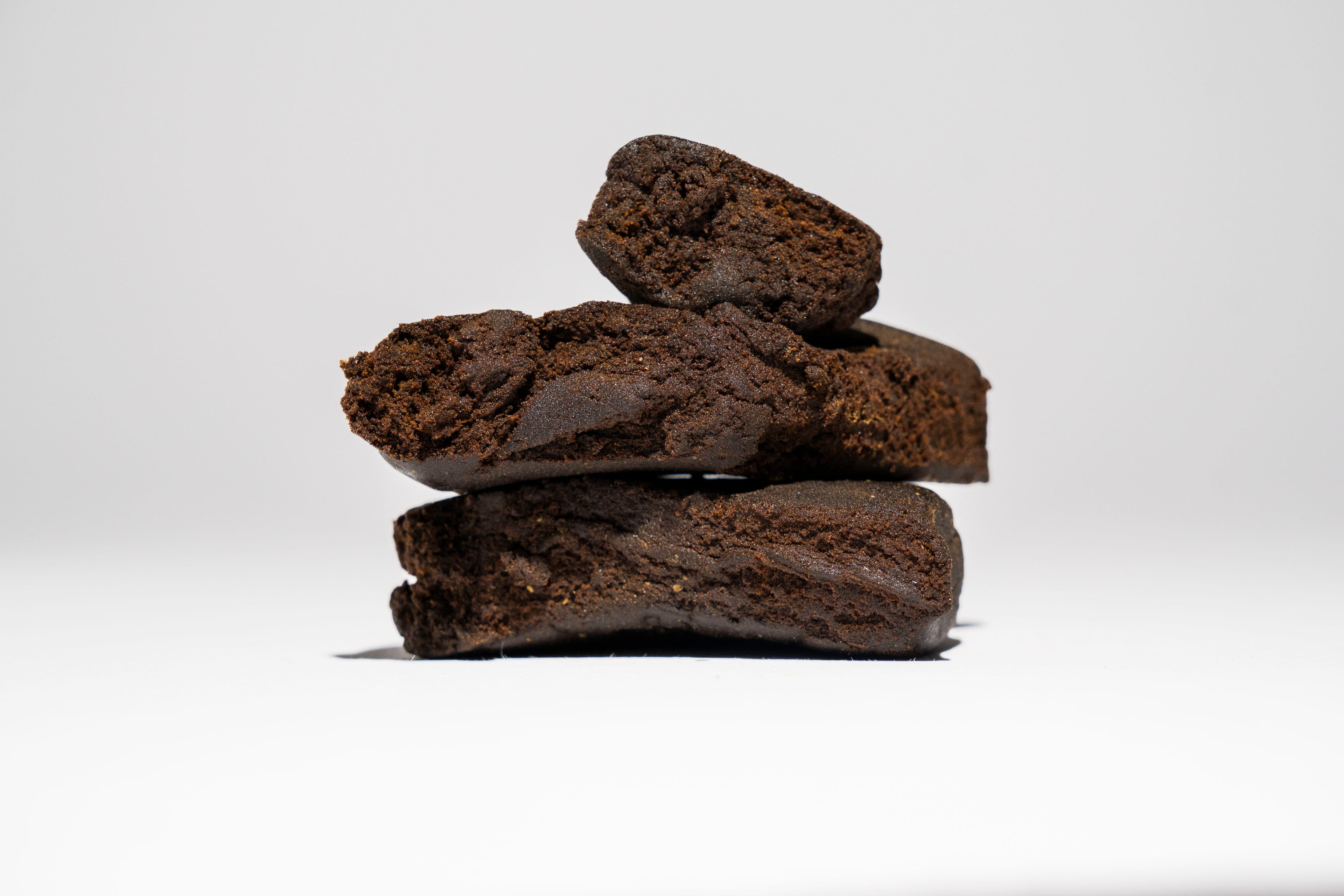 Stack of dark brown hash on a white background