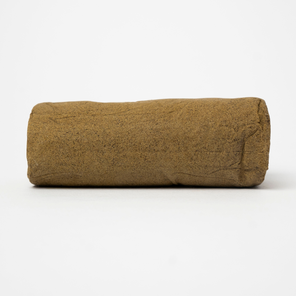 THCA Hash Mousse – soft cylindrical hash with airy texture and fine dry sift structure
