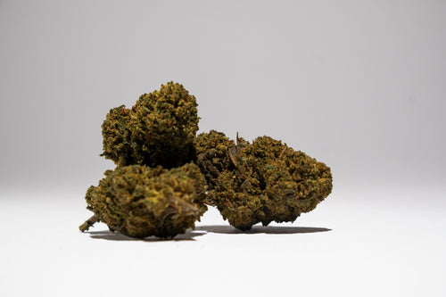 Three pieces of dried cannabis on a white background