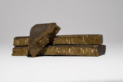 Three brown blocks of hash stacked on a white background